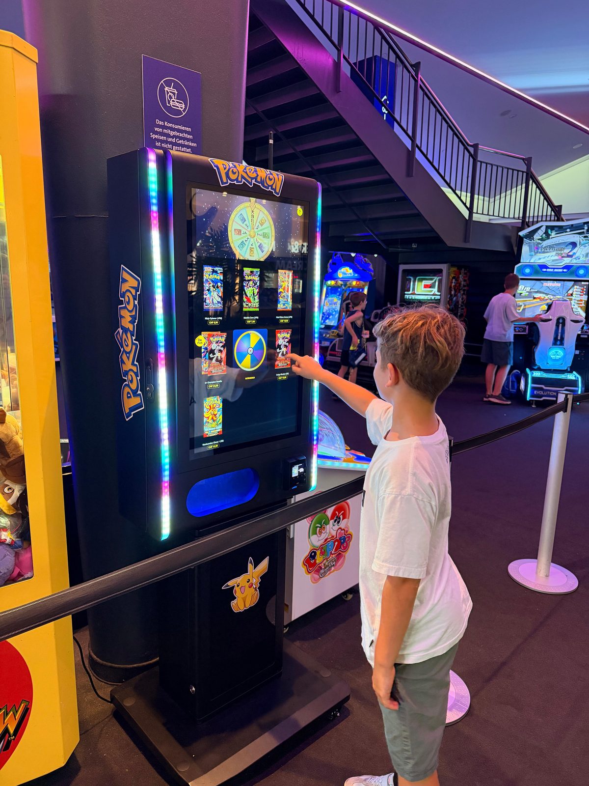 Ein Junge wählt Sammelkarten an einem Nova Prime in einer Spielhalle